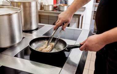 Cooking sausages in a pan. Grilled sausage in a skillet. Restaurant.