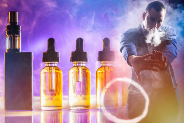 Smoke ring from an e-cigarette on the background of Smoking accessories. Vaper holds his hands out...