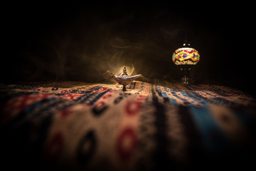 Lamp of wishes concept. Antique Aladdin arabian nights genie style oil lamp with soft light white...