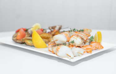 a dish of red fish on a white plate and on white dishes, haute cuisine