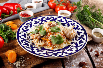 The concept of Oriental cuisine. Homemade Uzbek pilaf or lamb pilaf is served