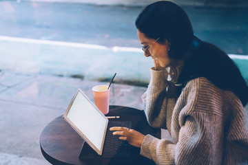 Woman sitting with ultrabook on street