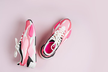 Fashion women's sneakers on a pink background. Female sport shoes.  Fitness concept. Top view, flat...