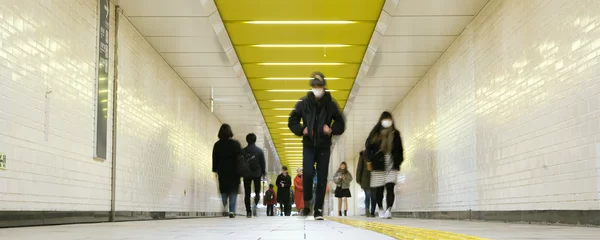 Foto op Plexiglas Pedestrians wearing surgical masks in subway station, Tokyo, Japan　マスクをつけた人々 東京の地下鉄駅の構内 © wooooooojpn
