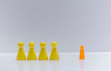 Orange pawn figure against united yellow, isolation, racism