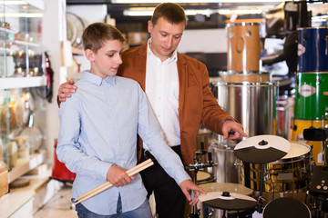 Boy and father choosing best drum