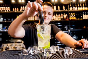 Bartender is making cocktail at bar counter. Fresh cocktails.