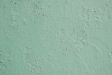 A thick layer of old green-blue paint with a swollen and cracked surface. Background