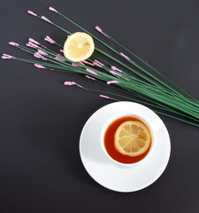 tea with lemon on a black background. Set: ceramic mug and saucer on a white background. Beautiful advertising background