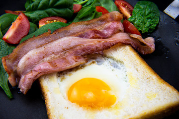 Egg in a hole bread and bacon with salad