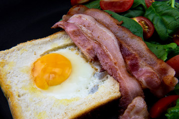 Egg in a hole bread and bacon with salad