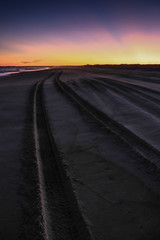 Samochodem po plaży o zachodzie słońca