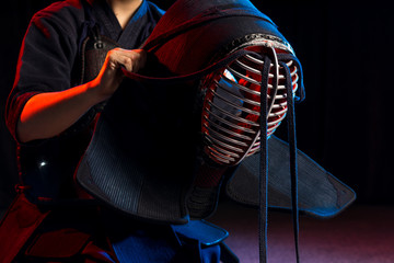 unrecognizable young kendo fighter wearing helmet, preparing for fight. japanese martial art,...
