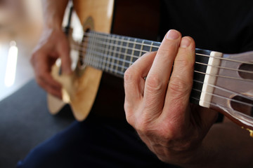 a man plays the guitar, close-up hands, the concept of creativity, learning to play musical...