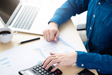 Businessman is inspecting and checking the business reports graphs to audit the financial reports...