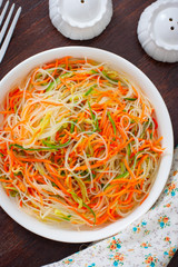 Funchose salad with fresh cucumbers and Korean carrots, selective focus, top view
