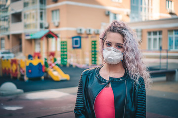 girl in protective medical mask on the playground