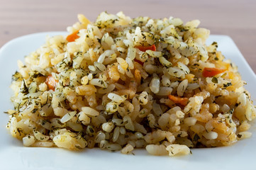 Rice with meat, vegetables and mushrooms on plate