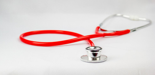 Red medical equipment stethoscope on white background foreground technology pattern,Used to measure abnormalities in the body and heart rate.