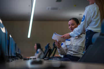 Security guard monitoring modern CCTV cameras in a surveillance room. Female security guards sitting having conversation monitoring cctv.