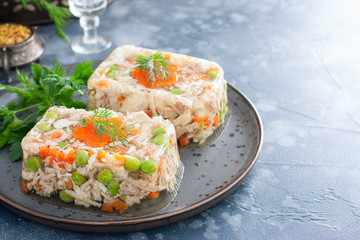 Homemade jelly with chicken, pork peas with slices of carrots, horizontal, copy space