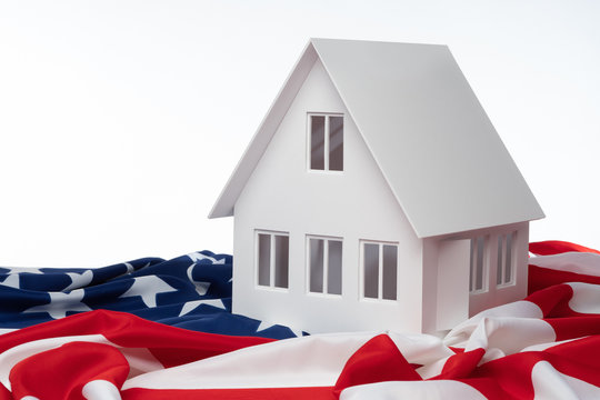 ?oncept Is Real Estate In The USA. Realtor In The United States. Rental Housing In New York. Home For Sale In The USA. Layout Of The House Next To The US Flag. Life In The USA. Emigration To America