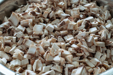 Raw chopped champignons in a bowl. Raw mushrooms are cut into small pieces