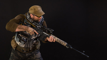 Soldier mercenary with a sniper rifle on a dark background