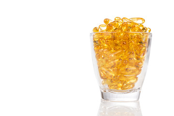 Glass filled with fish oil gel capsule containing omega-3 polyunsaturated acid EPA and DHA enhances heart and health.