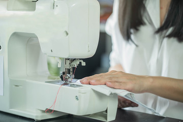Young female fashion designer working on her designs in the studio. Fashion designer drawing sketches for new collection. Beautiful fashion woman designer drawing in studio .