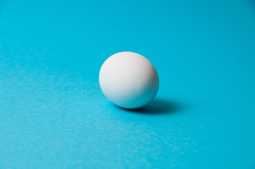 One white egg on a blue background. The concept of calorie content, life, healthy nutrition, Easter