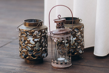 Copper candle holders with white candles as wedding decorations.