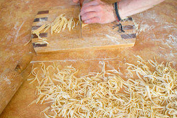 Pasta home makingcloseup in kitchen interior. The cooking process, raw pasta with flour