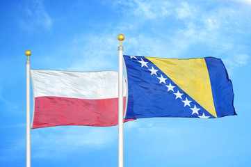 Poland and Bosnia and Herzegovina  two flags on flagpoles and blue cloudy sky