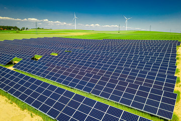 Stunning solar panels, green field and blue sky, aerial view