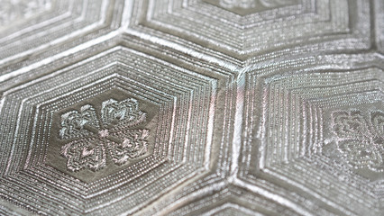 Background with macro closeup on a silver Japanese traditional clothing kimono waistband with hexagon shaped pattern