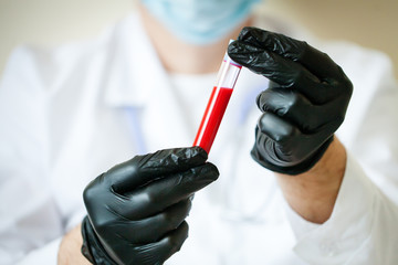 The epidemic of coronavirus. Hand of a doctor holding a bottle of blood sample.
