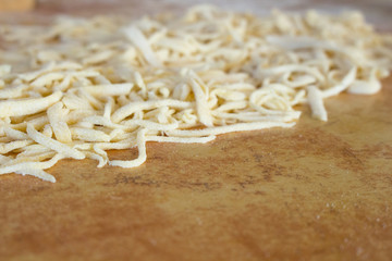 Pasta home makingcloseup in kitchen interior. The cooking process, raw pasta with flour