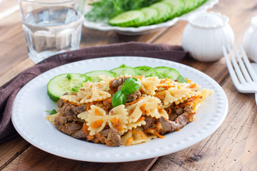 Farfalle with fried chicken liver and carrots, selective focus