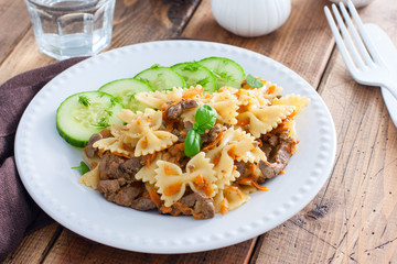 Farfalle with fried chicken liver and carrots, selective focus