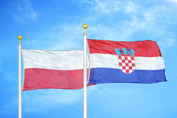 Poland and Croatia two flags on flagpoles and blue cloudy sky