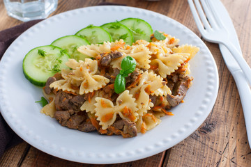 Farfalle with fried chicken liver and carrots, selective focus