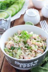 Smoked chicken salad with fresh cucumber in a white bowl, selective focus
