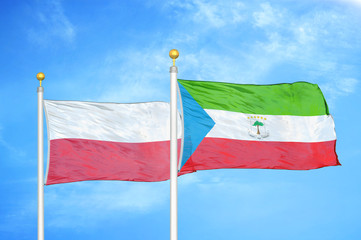 Poland and Equatorial Guinea two flags on flagpoles and blue cloudy sky