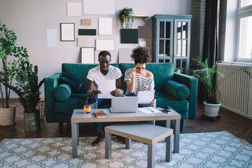 Shocked ethnic freelancer reading reports