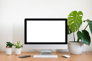 Blank screen of All in one computer, keyboard, mouse, monstera plant pot and small plant pots  on wooden table - obrazy, fototapety, plakaty