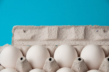 Eggs in a tray on a blue background. Conceptual photo with place for text.