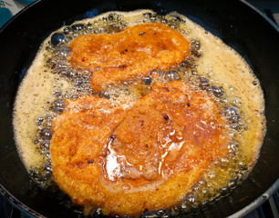 panierte Schnitzel in Butterschmalz braten