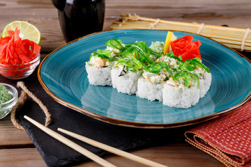 Rolls, wasabi, soy sauce, ginger on the table, avocado.