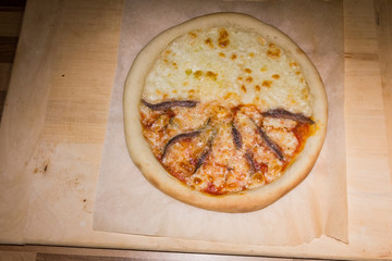 pizza fatta in casa alla salsiccia rucola e acciughe tipica napoletana 